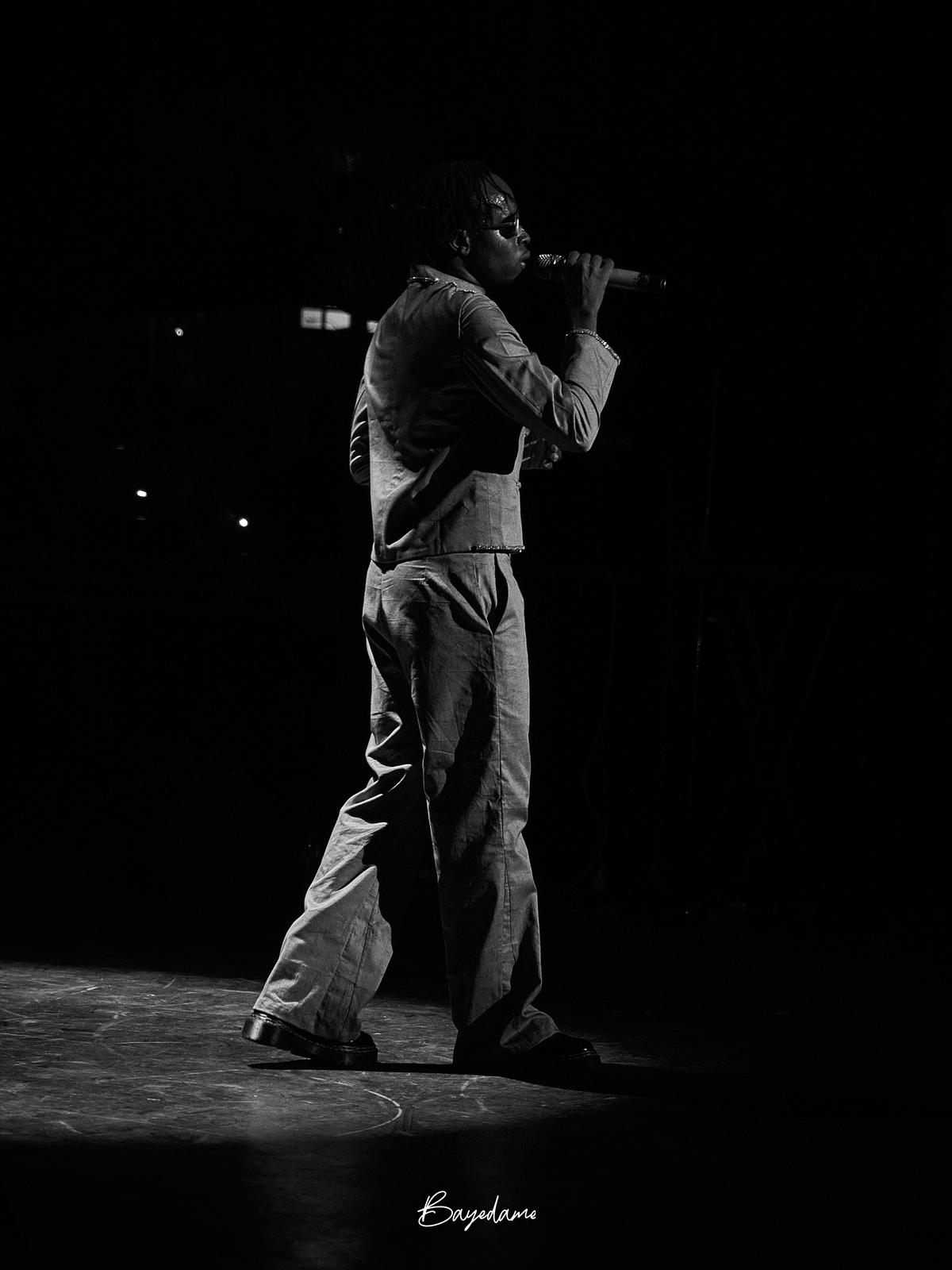 Chanteur au micro sur scène, noir et blanc — captation concert par Baye Dame